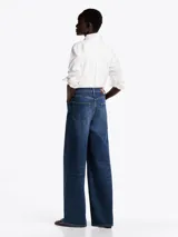 Pantalón de jean azul de pierna ancha y talle alto, con efecto desteñido y usado.