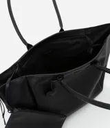 Bolso shopper grande de cuero sintético negro con asas medianas y cierre de cremallera. Incluye un dije colgante en forma de corazón y una pequeña cartera extra.