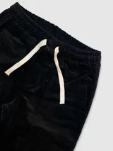 Pantalón de pana verde militar con cintura elastizada, cordón de algodón, bolsillos laterales y un bolsillo trasero.