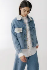 Campera de jean celeste con cuello y bolsillo con detalles de crochet blanco.