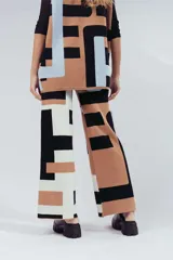 Pantalón de punto con estampado geométrico en tonos beige, negro y celeste.