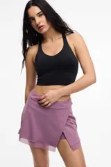 Short deportivo color lila con calza interna y bolsillo lateral. Presenta un frente cruzado y detalle de microtul.