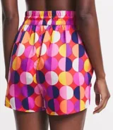 Short de playa con cintura elástica y lazo decorativo. Estampado de lunares grandes en tonos rosa, naranja, amarillo, blanco y violeta.