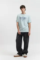 Remera celeste de manga corta con cuello redondo y estampado con letras en el frente.