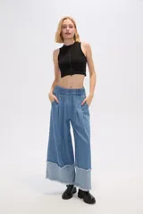Pantalón de jean azul de corte ancho y tiro alto, con bolsillos y pinzas.