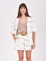 Camisa de manga corta con estampado de motivos marinos, cuello clásico y cierre frontal con botones.