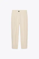 Pantalón color crema de tiro alto con pinzas delanteras y cintura elástica en la espalda. Tiene bolsillos delanteros y traseros.