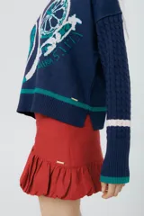 Buzo azul marino tejido en jacquard con diseño de frutas y verduras. Tiene mangas tejidas en ochos, bordado en la espalda y puños con agujerito para el dedo.