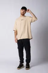 Remera color beige de corte oversize, con cuello redondo y mangas cortas. Estampa pequeña en el frente con la frase "Fresh from the vine".