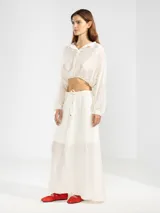 Blusa corta celeste de tejido arrugado liviano, con cuello mao, botones al frente, mangas abullonadas y ruedo elastizado.