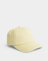 Gorra amarilla de gabardina con bordado de cerezas blancas en el frente y hebilla metálica ajustable en la parte posterior.
