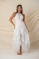 Vestido largo de tul color nude con apliques de encaje blanco y corte irregular.