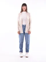 Saco color beige de tejido de punto, con cuello abierto, bolsillos frontales y mangas largas con detalle de botones en los puños.