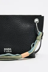 Bolso bandolera de piel color negro, con estructura blanda y tamaño mediano. Asa combinada de piel y cordón, logo estampado y acabados metálicos. Bolsillo interior, cierre con cremallera e interior con etiqueta de tejido BIMBA Y LOLA.