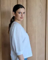 Blusa blanca de mangas 3/4 abullonadas con escote en V.