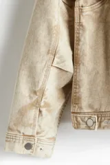 Campera color beige de sarga de algodón con efecto lavado, corte holgado, cuello clásico, cierre frontal con cremallera, bolsillos delanteros de parche, bolsillo interior con botón a presión, botones a presión ajustables en los puños y en los laterales del bajo y forro interior.