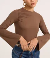 Blusa manga larga godê color borgoña, confeccionada en microfibra con fruncido en los hombros y laterales.