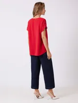 Blusa azul de crepe, marca Ninety Clothing, con cuello a la base y manga corta con presilla y botón.