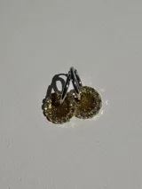 Aros colgantes con dije circular de resina dorada y strass, con arito de acero quirúrgico. El dije mide aproximadamente 1.5cm de diámetro.