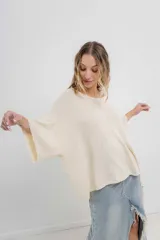 Sweater color crudo de tejido liviano con textura semi traslúcida, escote redondo y mangas amplias estilo murciélago.