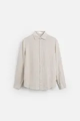 Camisa celeste de lino, de corte recto, manga larga y cuello clásico.