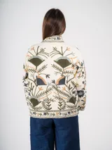 Chaqueta abierta color crema con bordado floral multicolor, corte cuadrado y mangas largas.