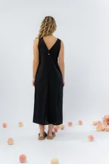 Vestido midi de lino en color verde seco, con escote en V, diseño sin mangas y cierre frontal con botones de madera. Presenta un corte recto y fluido con una abertura frontal en el bajo.