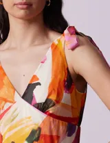 Vestido largo estampado de gasa, con escote en V, corte bajo el busto, lazos en los hombros, corte en la cintura, superposición de capas con volados, abertura central en la espalda con cierre invisible y forro interno a tono.