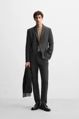 Pantalón de vestir slim fit color gris oscuro, confeccionado en tejido con viscosa. Cuenta con bolsillos frontales y traseros de vivo. Cierre frontal con cremallera y botón.