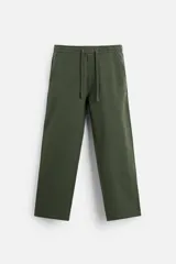 Pantalón verde militar de corte amplio, con cintura elástica ajustable con cordón, bolsillos laterales y traseros.
