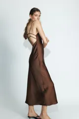 Vestido midi de tejido satinado color celeste pálido, con escote en V y tirantes finos ajustables. Presenta un detalle de tiras cruzadas en la espalda.