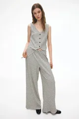 Pantalón de pierna amplia en tejido de punto acanalado a rayas. Modelo con cintura elástica y cordón ajustable.