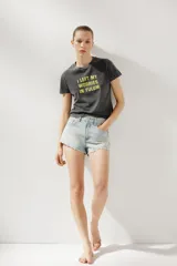 Camiseta color crema de algodón con efecto lavado, corte regular, cuello redondo, manga corta y texto marrón estampado en el frente con la frase 'Sun-Kissed in Maldives'.