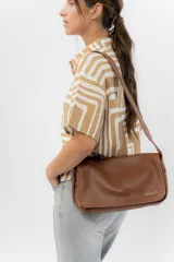 Bandolera moderna de eco cuero texturado color negro, con solapa frontal con cierre magnético oculto y correa regulable para llevar al hombro o cruzada.