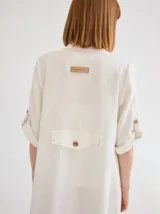 Vestido camisero largo color blanco, de lino, con cuello camisero, abotonado al frente y mangas 3/4 con botón.