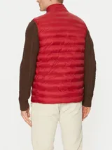 Chaleco rojo Tommy Hilfiger plegable, con cuello chimenea, cierre de cremallera, dos bolsillos laterales con cremallera y logo bordado en el pecho. Confeccionado en tejido de nailon que repele el agua.