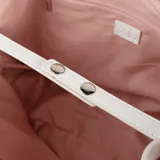 Cartera tipo shopper color blanco, confeccionada en símil cuero texturizado. Tiene doble asa de mano, correa bandolera regulable y herrajes plateados. El acceso es con cierre. Interior forrado en tela de algodón y poliéster con un bolsillo con cierre y dos bolsillos abiertos.