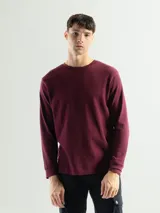 Remera negra de manga larga con cuello redondo, confeccionada en tejido mini piqué de algodón.