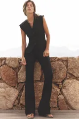 Pantalón negro de tiro alto confeccionado en tejido de punto elástico y flexible con trama compacta, mullida y opaca. Bajo acampanado.