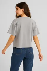 Remera blanca de corte holgado con estampado de flores negras.