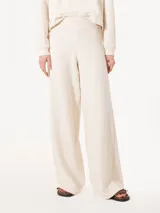 Pantalón de punto color crudo con lurex, cintura elastizada y piernas anchas.