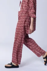 Conjunto de pantalón palazzo con aberturas laterales y kimono largo con estampado geométrico en tonos rosa y beige. Incluye un top blanco de algodón.