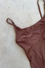Traje de baño enterizo marrón con breteles finos, escote en U y espalda redondeada.