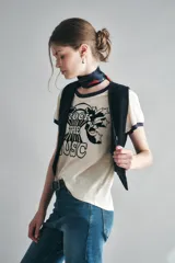 Remera color crema de algodón con cuello y mangas con ribete azul marino. Estampado frontal con la frase "Rock the Music" en letras negras con detalles de estrellas.