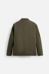 Blazer color verde oliva de algodón con efecto lavado, corte relaxed fit, cuello con solapas de muesca, manga larga y bolsillos frontales de plastrón. Cierre frontal con dos botones.
