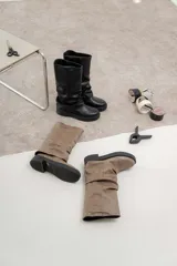 Bota alta color beige con efecto arrugado, suela track color negro y caña alta.