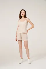 Conjunto de pijama de satén a rayas verticales color beige, compuesto por un top con breteles finos y escote en V, y un short de calce holgado.