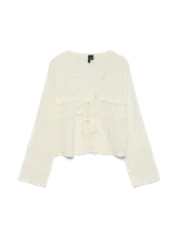 Blusa color blanco hueso de algodón con cuello en V y volados. Tiene mangas largas, cierre de lazo al frente y calce regular.