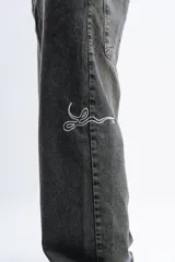 Pantalón de jean azul oscuro con efecto desgastado, corte mega baggy, bolsillos grandes y bordado lateral con el logo de la marca en color blanco.