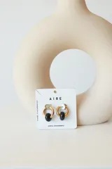 Aros de acero quirúrgico hipoalergénico con piedras naturales azules. Diseño de aro con dije circular colgante.